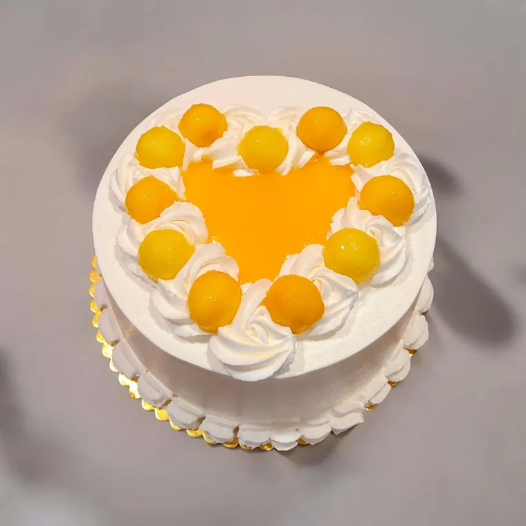 Gâteau blanc décoré de dômes à la mangue disposés en cœur