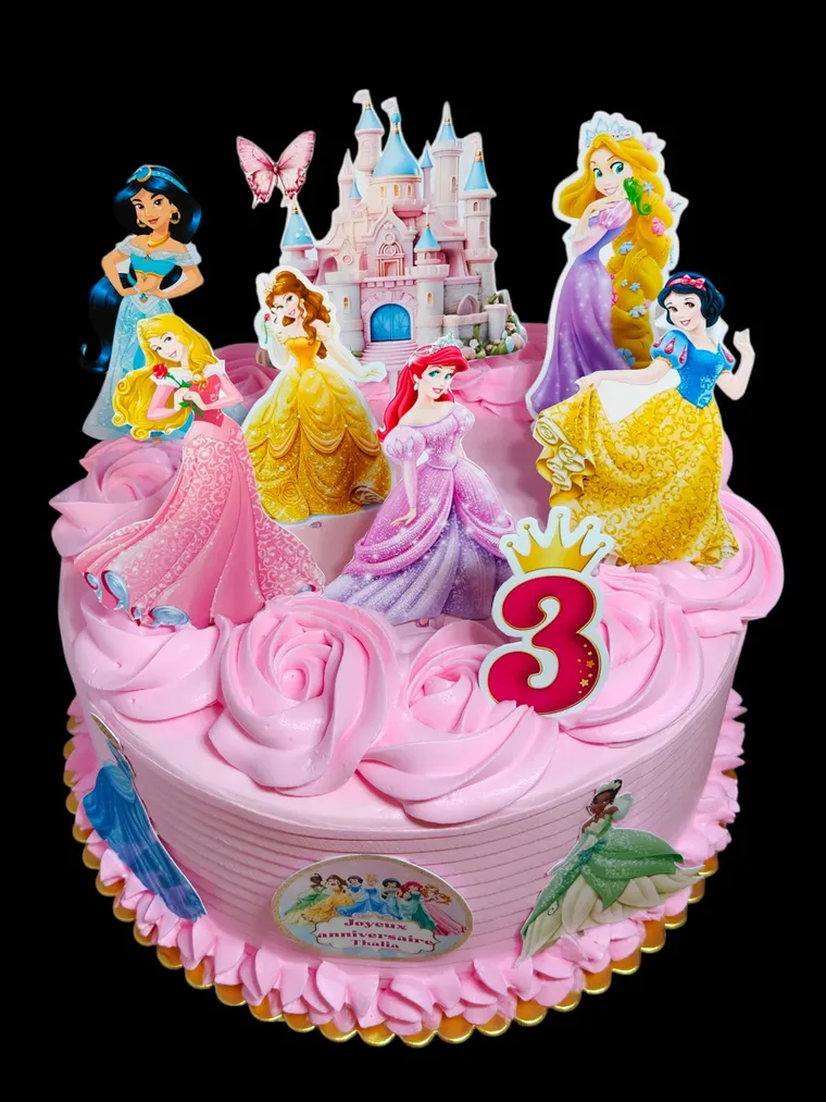 Gâteau rose surmonté d’un château et de figurines de princesses