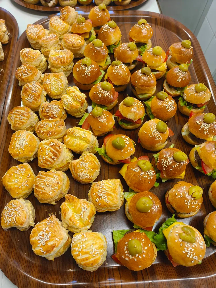 Plateau de mini-feuilletés au sésame et de mini-burgers piqués d’une olive