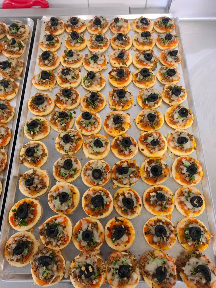 Mini-pizzas garnies de viande hachée, fromage et olive noire, sur plaque de four